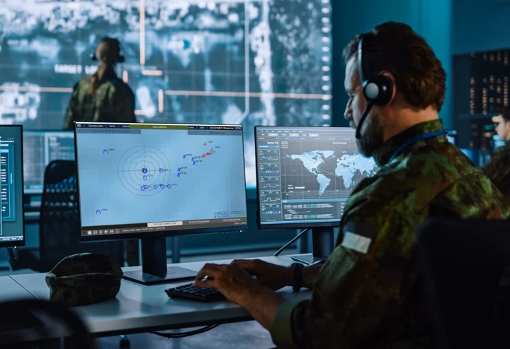 Military man using the C4ISR data management software on his computer.